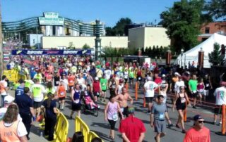 a photo of a large group of people all crossing a finish line after running a 9 mile race