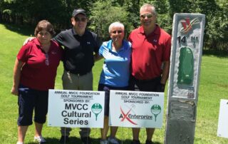 a photo of 4 people standing on hole 14 of a golf course during a golf outing