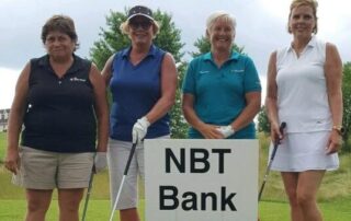 a photo of 4 ladies standing at a golf tee for a golf outing with NBT Bank